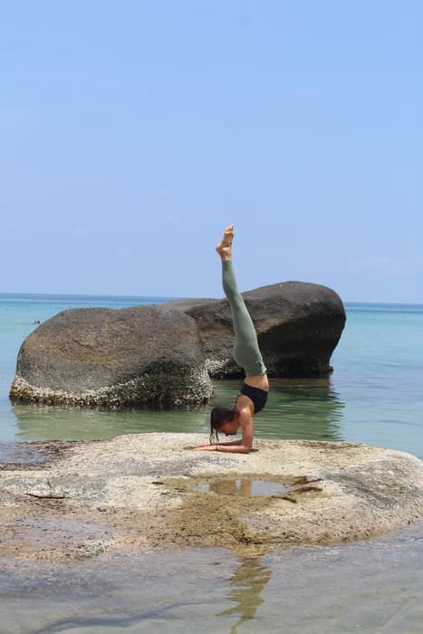 Handstand on a rock in the shallows